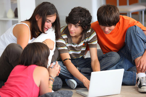 Group of teenagers in front of a laptop computer
