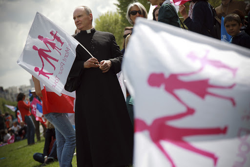 A Catholic priest holds a flag among supporters of the anti-gay marriage movement &#8220;La Manif Pour Tous&#8221; &#8211; it
