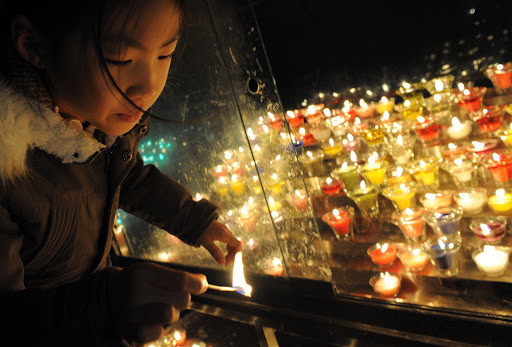 A South Korean girl lights candles at Myeongdong Catholic Cathedral in Seoul &#8211; it