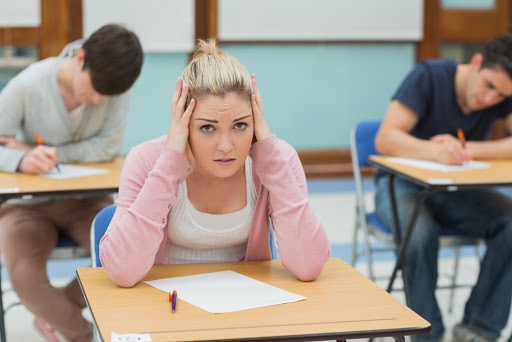 Student sitting at a table in a classroom while having an examination