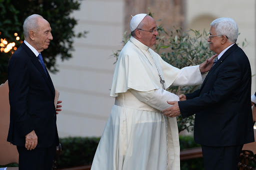 Pope Francis (C) shakes hands with Palestinian leader Mahmud Abbas (R) as Israeli President Shimon Peres &#8211; AFP