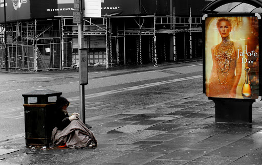 Pobre delante a un cartel publicitario &#8211; it