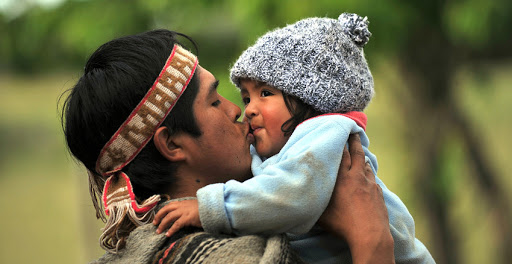 Padre mapuche besando a su hijo &#8211; it