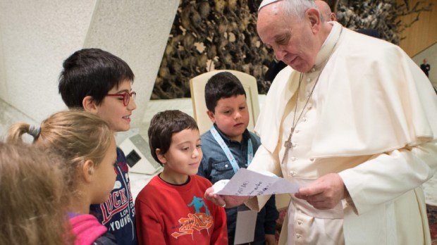 November 22, 2014: Pope Francis reads a letter he received from some children as he meets with the participants at the missionary meeting of the Italian bishops&#8217; conference in the Paul VI hall at the Vatican.