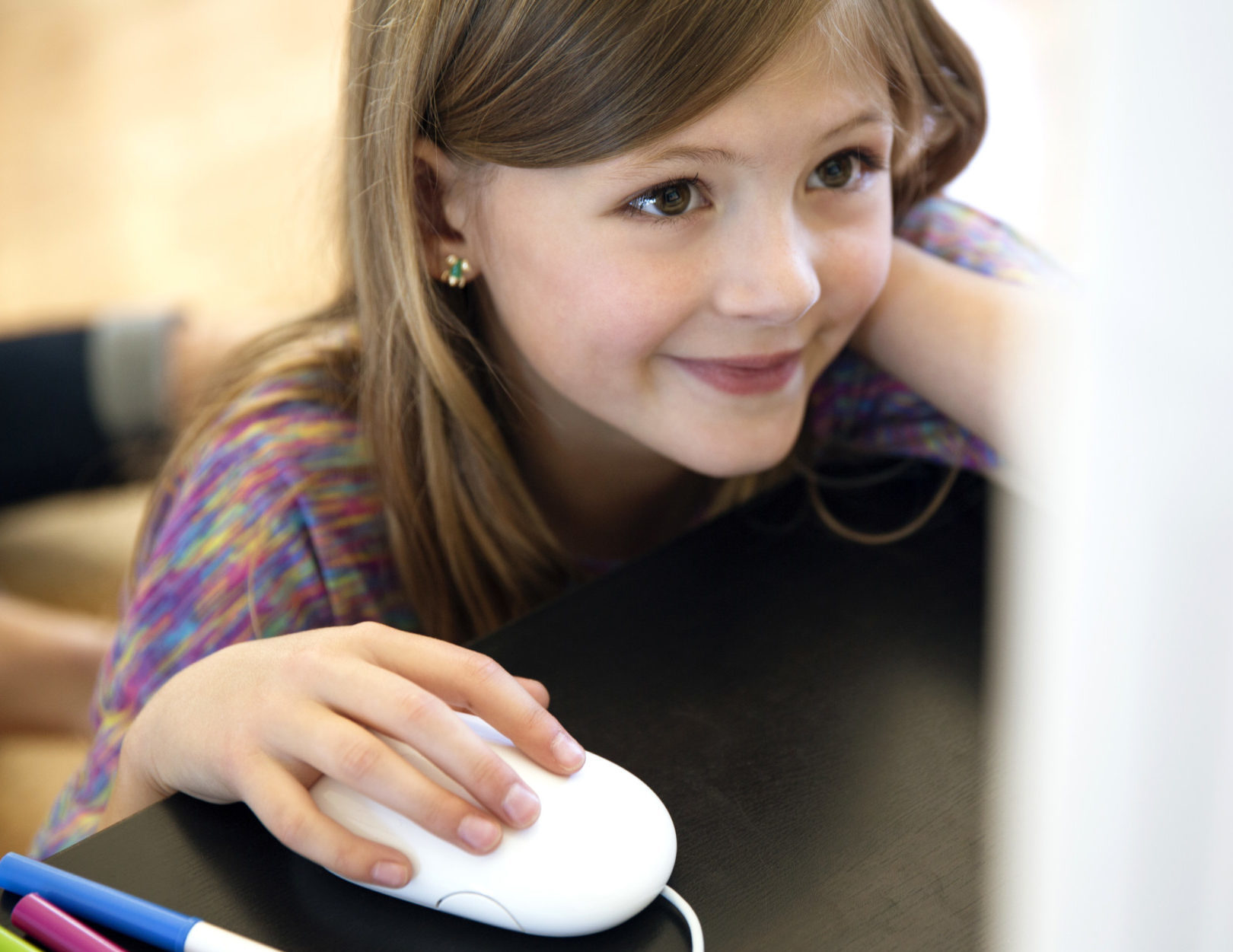Little girl using computer mouse at table