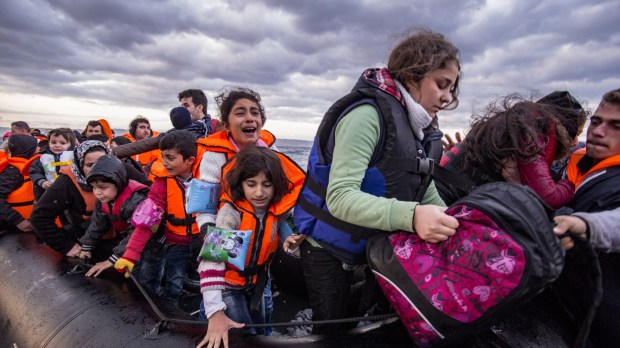 Lesvos island, Greece &#8211; 29 October 2015. Syrian migrants / refugees arrive from Turkey on boat through sea with cold water near Molyvos, Lesbos on an overload dinghy. Leaving Syria that has war.