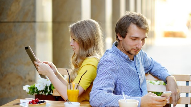 Preview Save to a lightbox Find Similar Images Share Stock Photo: Young couple using smart phone and tablet pc in the outdoor cafe
