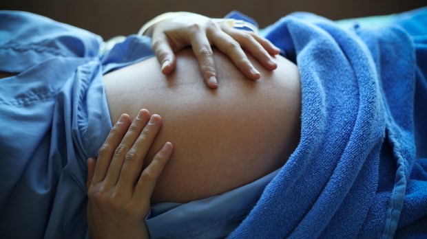 WEB-WOMAN-PREGNANT-BELLY-HANDS-HOSPITAL-Sakhorn-Shutterstock_125744078