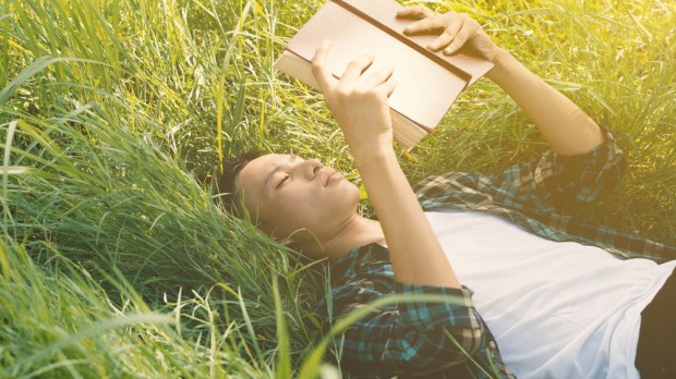 web-young-man-reading-bible-grass-pornsawan-sangmaneeshutterstock