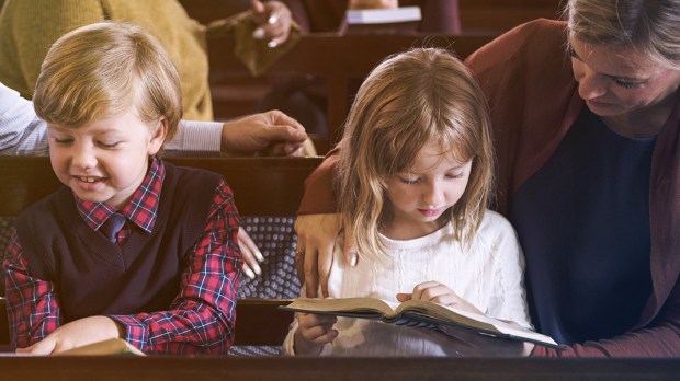 WEB3-CHILDREN-CHILD-READING-CHURCH-PEW-MOTHER-WOMAN-Shutterstock