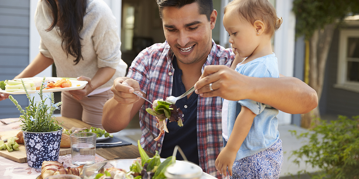 WEB3-FATHER-MAN-MOTHER-WOMAN-CHILD-DAUGHTER-EATING-SALAD-DINNER-Shutterstock