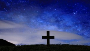 Wood cross over a dark night starry sky