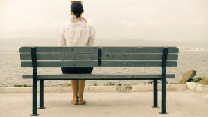 FEMME ASSISE SEULE SUR UN BANC