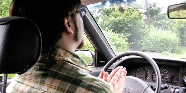 MAN PRAYING IN CAR
