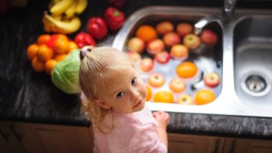 LITTLE GIRL WASHING FRUIT