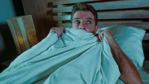 sleepless young man lying in bed stressed and scared suffering n