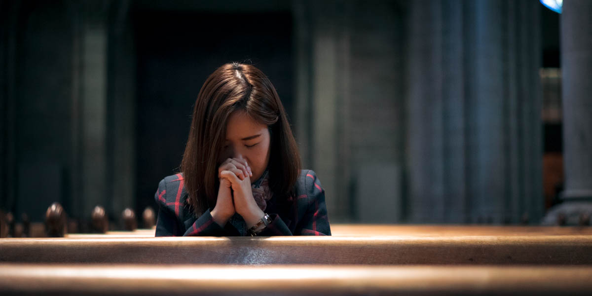 WOMAN PRAYING,CHURCH PEWS