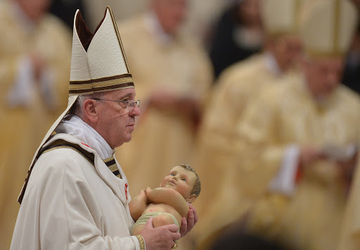 Pope Francis holds the unveiled baby Jesus during a Christmas Eve mass – pt