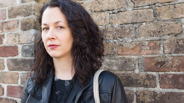 web2-serious-woman-with-dark-curly-hair-and-black-clothes-in-front-of-old-brick-wall-shutterstock_362487701.jpg