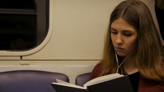 girl reading a book in subway