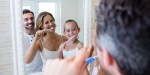 Parents and daughter brushing their teeth