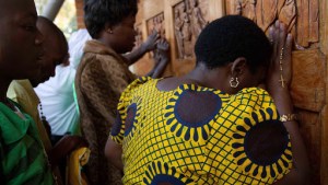 Ugandan women pray at the relief doors of the Martyrs shrine in Namugongo – ar