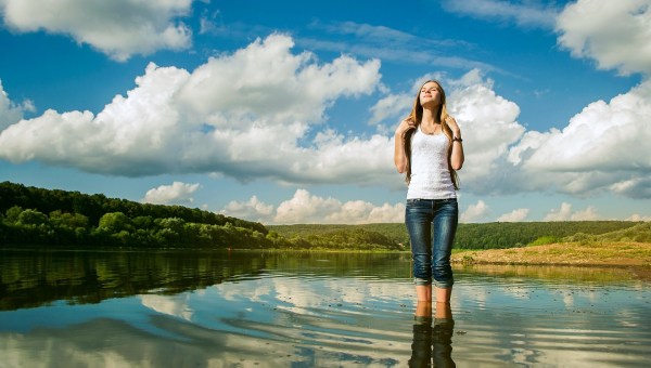 mujer bañando sus pies en un río