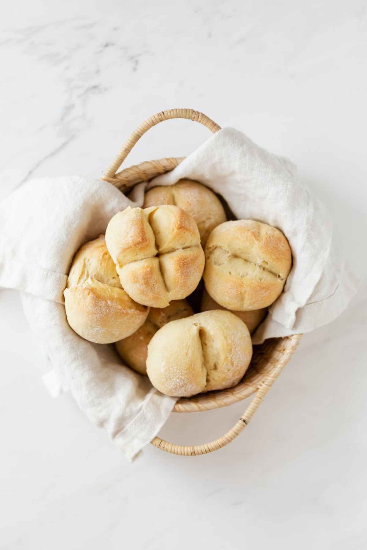 basket with fresh swiss buns on marble table