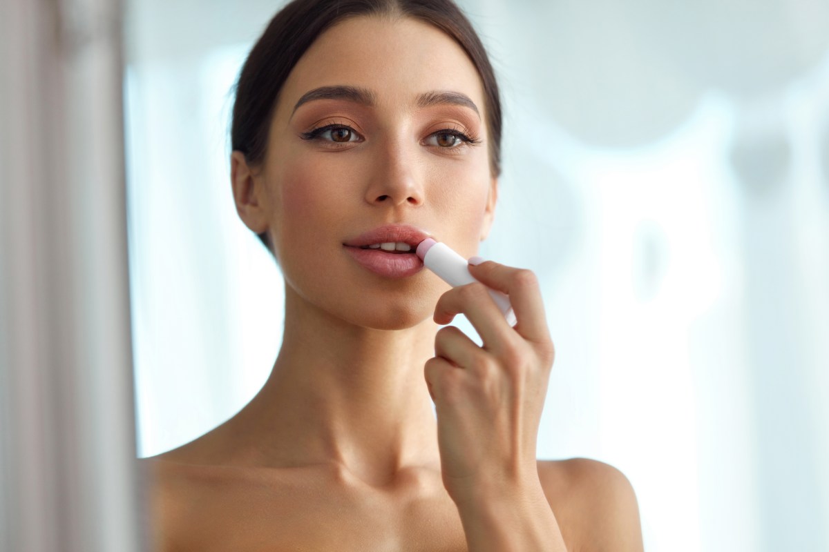 DONNA SI SPECCHIA E SI METTE IL ROSSETTO