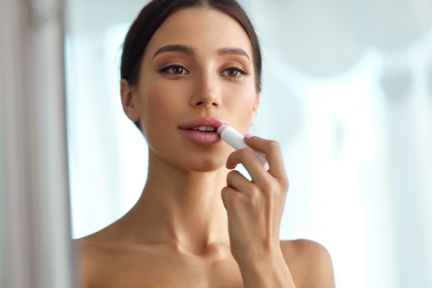 DONNA SI SPECCHIA E SI METTE IL ROSSETTO