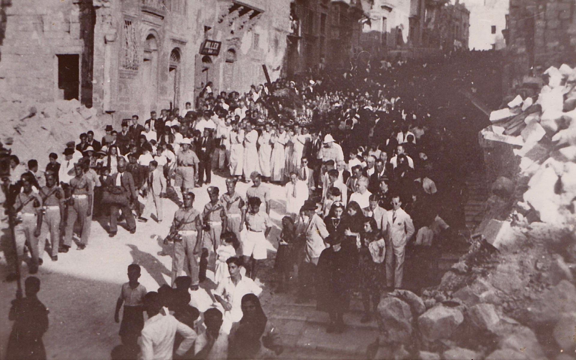 6.-A-1944-huge-procession-with-the-Redeemer-of-Senglea-a-year-before-the-War-ended.-The-rubble-and-debris-from-the-bombings-can-be-seen-on-the-sides-�-Courtesy-of-Fr.-Dr.-Jonathan-Farrugia.jpg