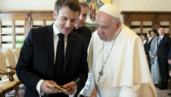 prezydent Francji Emmanuel Macron ogląda książkę, którą przywiózł jako prezent dla papieża