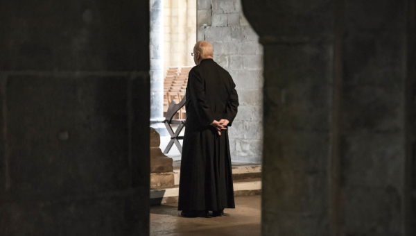 Starszy ksiądz w kamiennym kościele