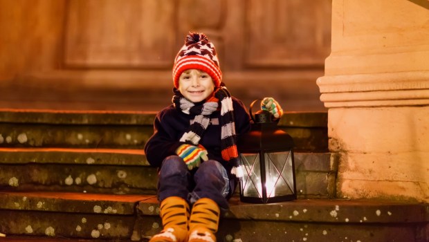 BAMBINO CON LANTERNA SU SCALE DI UNA CHIESA