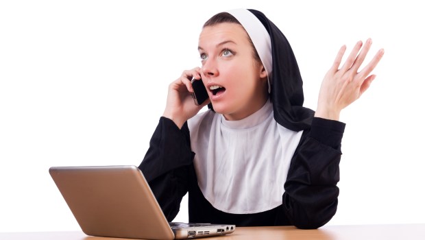 SUORA PARLA AL TELEFONO DAVANTI AL PC PORTATILE