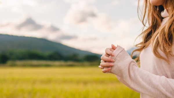Young woman praying in nature