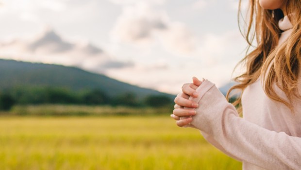 Young woman praying in nature