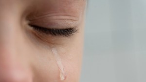 Close up image of teardrop rolls down the boys cheek his eyes are closed he is upset and crying Sad unhappy emotions of child