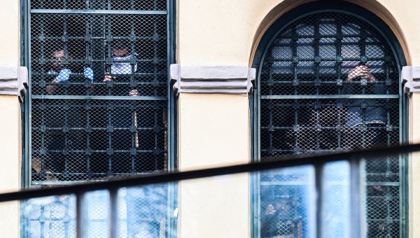 Inmates-hang-on-to-bars-behind-windows-of-a-wing-as-they-stage-a-protest-at-the-San-Vittore-prison-in-Milan-AFP