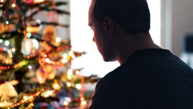 Lonely christmas with sad family conflict or grief on holiday Man with stress