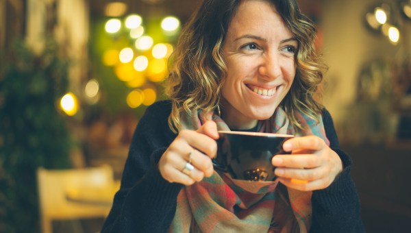 donna con smart phone in caffetteria