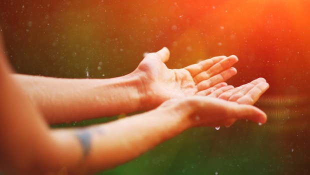 Womans hand catch rain drops