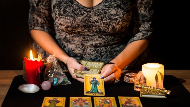womans-hands-placing-tarot-cards-shutterstock