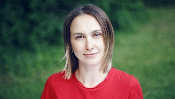 Portrait head shot of beautiful pensive Caucasian middle age woman with long light bob hair Casual style real person in red tshirt Closeup face of happy calm woman in park outside nature