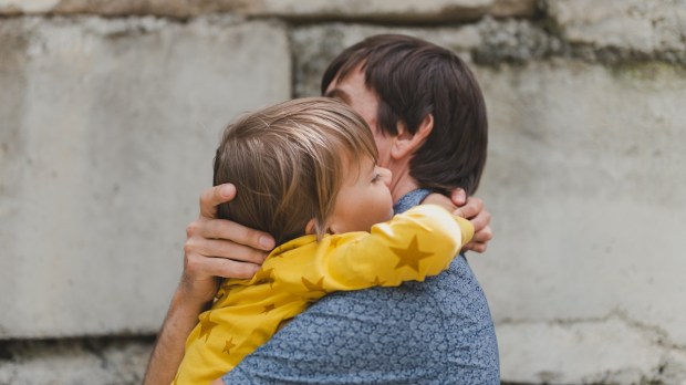 man dad having quality time with their kid son boy six year old hug on arms happy father playing together with child real life authentic day to day fatherhood moments