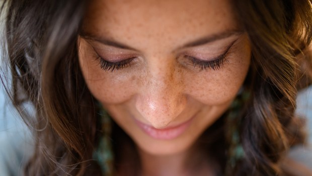 Mujer sonriente mirando hacia abajo